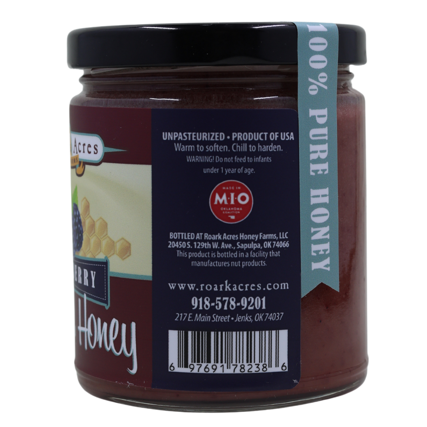 Jar of blackberry honey with a label on a white background